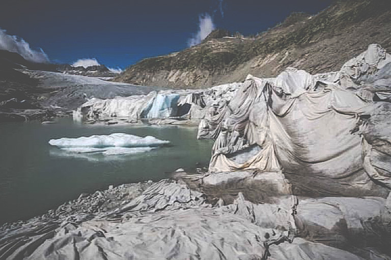 TOPSHOT - This photograph taken near Gletsch, in the Swiss Alps, on July 8, 2022 shows insulating foam covering a part of the Rhone Glacier to prevent it from melting next to its glacial lake, formed by the melting of the glacier due to global warming.  (AFP)